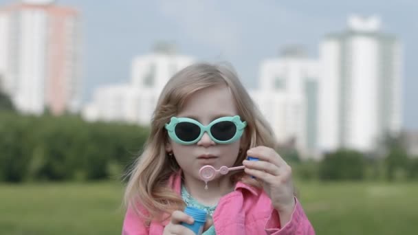 Маленькая девочка дует мыльный пузырь наружная природа — стоковое видео