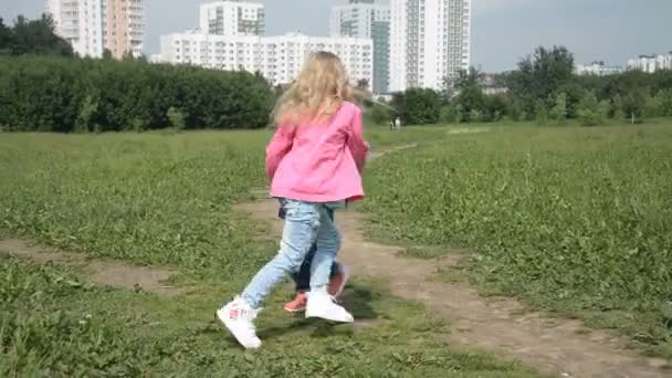 도시 공원의 잔디밭에서 두 자매 가손을 잡고 빙빙 돌고 있다. 자유와 태평 스러운 개념 — 비디오