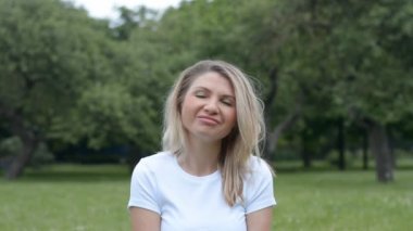 Yazlık parktaki beyaz tişörtlü 35 yaşındaki güzel beyaz bir kadının portresi.