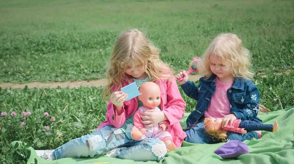 Twee zussen spelen in het park op het gras — Stockfoto