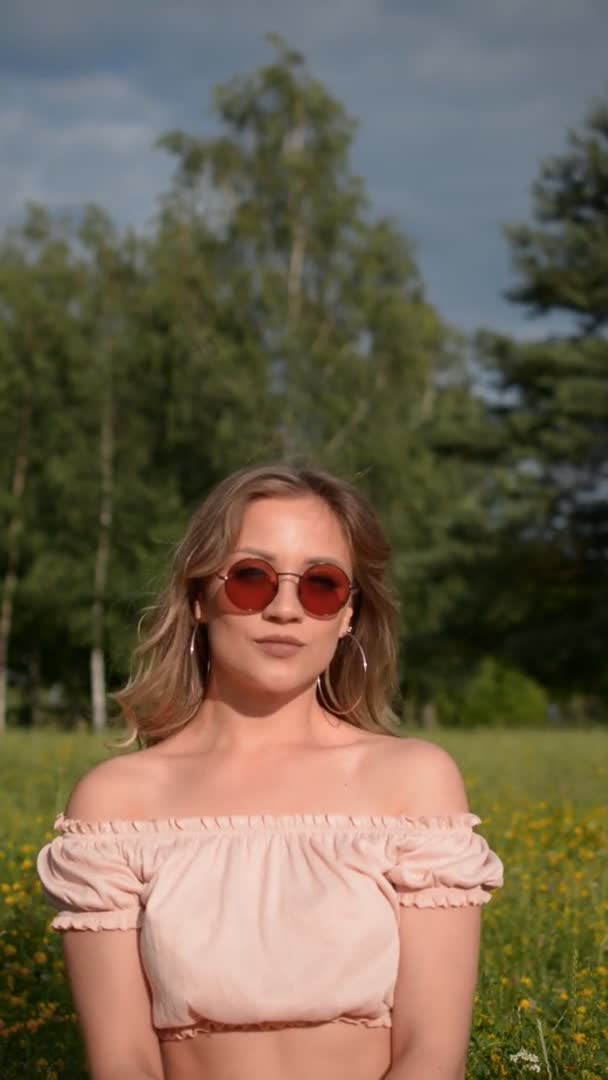 Portrait vertical d'une fille en lunettes de soleil dans le parc d'été — Video