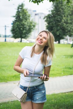 Bir yaz günü tablet kullanan genç bir kadın.