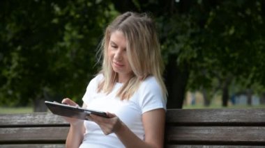 Kadın parkı kullanarak bir tablete yazıp çiziyor.