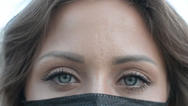 Primer plano de imágenes de ojos femeninos grises con mascarilla negra en la cara — Vídeos de Stock