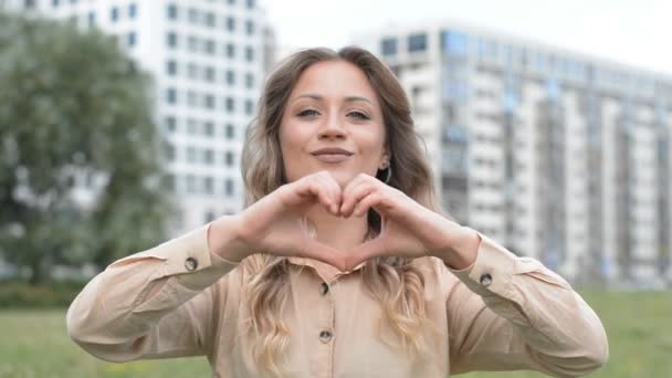 Bella giovane ragazza ritratto gesticolando cuore mani — Video Stock