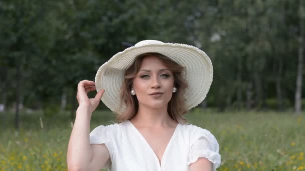 Portrait d'une belle fille blanche dans un grand chapeau blanc et robe blanche — Video