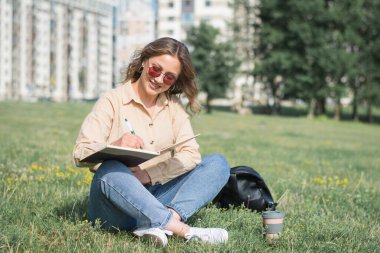 Bir yaz günü kampüs bahçesinde beyaz bir kız öğrenci.