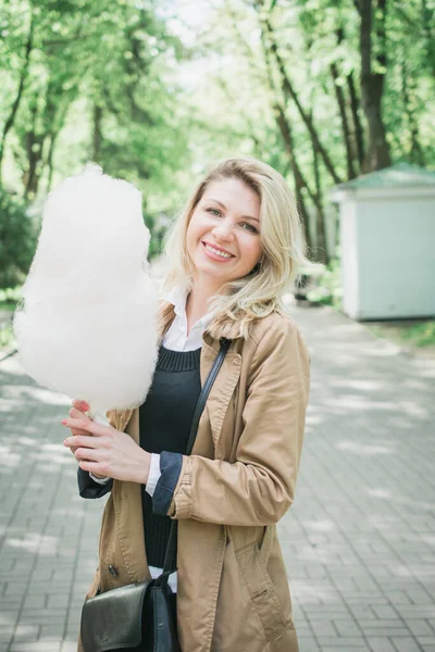 Ritratto ravvicinato di una ragazza sorridente che tiene lo zucchero filato — Foto Stock