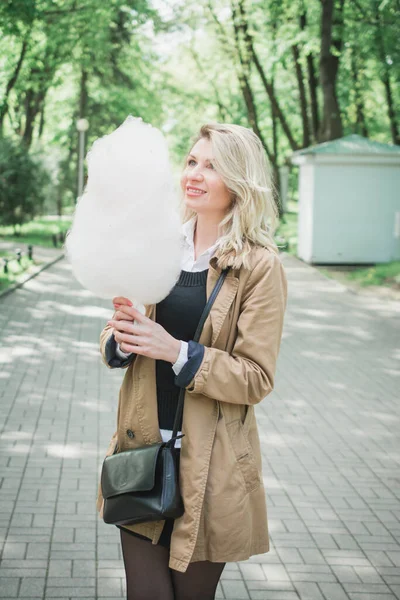 Ritratto ravvicinato di una ragazza sorridente che tiene lo zucchero filato — Foto Stock