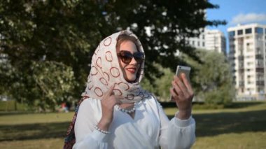 Online video görüşmesi sırasında cep telefonunu kullanan genç bir kadın.