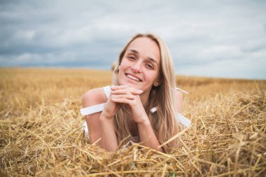 Mutlu kadın altın buğday tarlasında hayatın tadını çıkarıyor.