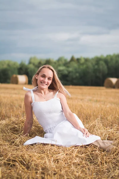 Lycklig kvinna njuter av livet i gyllene vetefält — Stockfoto