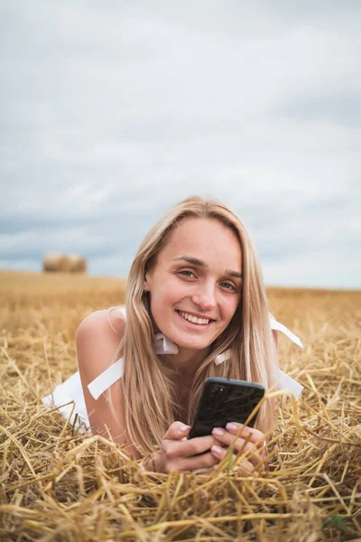 Lycklig kvinna njuter av livet i gyllene vetefält — Stockfoto