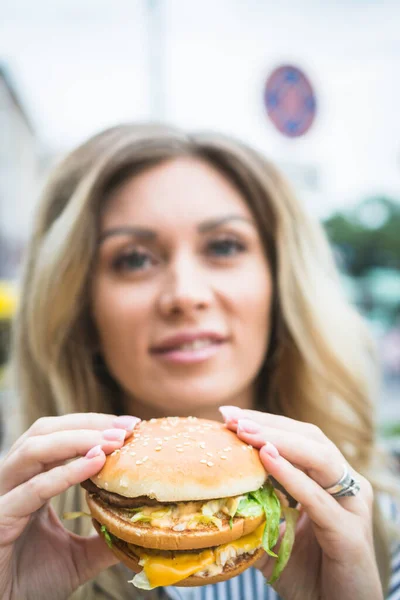 Κορίτσι Που Κρατά Ένα Cheeseburger Χάμπουργκερ Στα Χέρια Της Ένα — Φωτογραφία Αρχείου