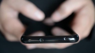 Akıllı telefondan yazı yazan erkeklerin yakın plan görüntüleri.