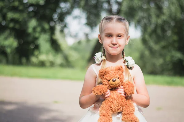 Klein Meisje Met Teddyberen Haar Handen Een Zomerpark — Stockfoto
