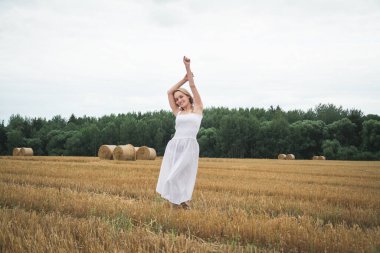 Bulutlu bir günde, buğday tarlasında güzel bir kız