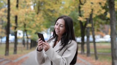 Sonbahar parkında siyah saçlı bir kadın portresi.