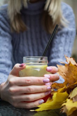 Bitkisel çay fincanı ile kadın elinin yakın çekimi.