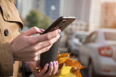 Kızın elleri telefonuna bir mesaj yazıyor. Kapat.