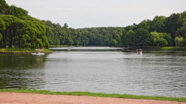 Moskova / Rusya 07 16 2019: Tsaritsino Yukarı Göleti Turistlerle dolu Katamaranlılar, Tsaritsino Park Müzesi 'nde yaz günü yeşil ormanlı sakin sular