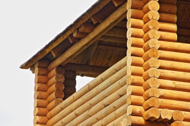 Yeni ahşap ev, Rus tarzı kır evi. Güneşli bir yaz gününde balkon parçalı.