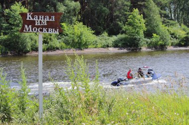 Moskova kanalı işaret levhasında Rusça hızlı yüzen şişirilebilir motorlu tekne, yaz günü ormanlık alanda, gemi hız sınırı 15 km / saat.