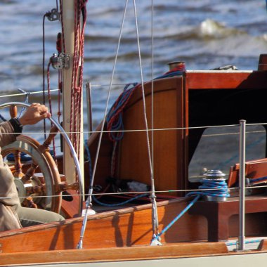 Güzel bir eski yelkenli yat bir yaz günü suda yüzer, ahşap kokpitten çekilen direksiyon iç mekan manzarası, yatla gezen açık hava eğlencesi