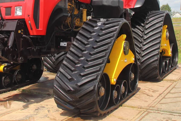 Rubber triangle crawls on new modern off road powerful heavy crawler tractor suspension front side view close up on Sunny summer day outdoor