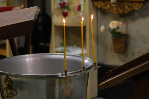 Baptismal font with lighting candles, a rite of Christening party in a Christian Church