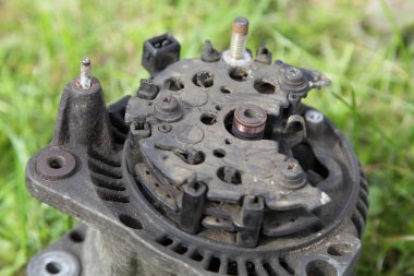 Kullanılmış araba 12 V alternatör röle gerilim regülatörü olmadan yakın plan yeşil çimen arka kapağı, açık hava aracı elektrikli teçhizat onarımı