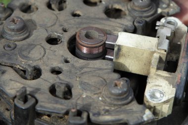 Kullanılmış araba 12 V alternatör servisi, eski temas halkaları makara ve entegre röle regülatörü yakın çekim, araç elektrikli teçhizat onarımı