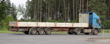 Yaz günü banliyöde asfaltlanmış yolda yarı karavanı boş yarı karavan trolü, arkadan görüş, lojistik, ulaşım, taşımacılık, taşımacılık...