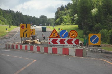 Yol onarım alanının sapması, trafik yönü ok işareti ve hız sınırı. Banliyö otobanının sağ şeridinde beyaz çitte saatte 50 km hız sınırı.