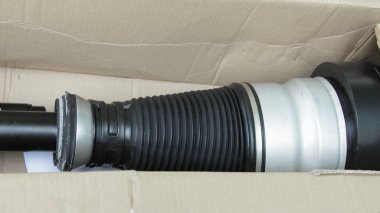 Karton kutuda yeni bir hava süspansiyonu askısı. Lüks zırhlı araç parçası için pnömatik şok emici.