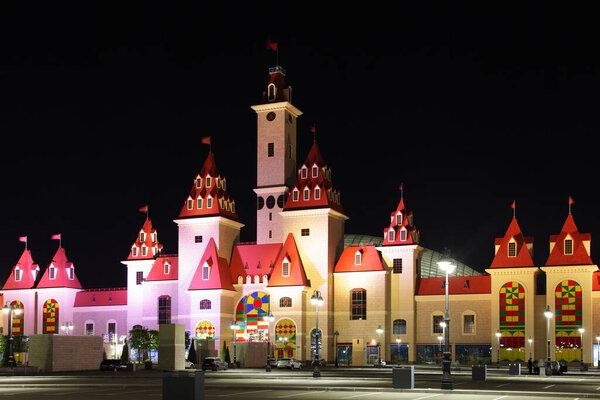 Moscow / Russia  09 02 2020: Modern fairytale children's family Park Island of Dreams on a summer night, a magic castle beautiful towers with color illumination on Russian Disney land