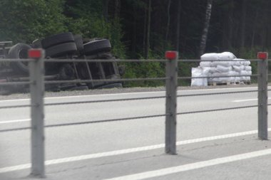 Yük çantalarda, devrilmiş kamyonun yanında bir palette. Yol kenarındaki hendek kazasında, patinajda, yaz gününde ağaçların arkasında trafik kazasında.