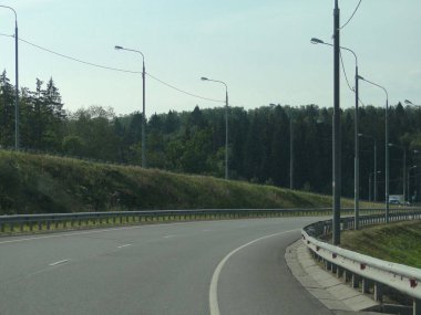 Odintsovo Moskova bölgesinde yaz günü mavi gökyüzü arka planında modern boş otoyol dönüşü
