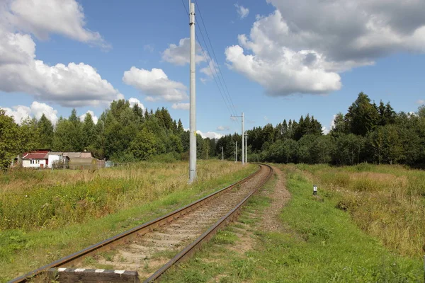 Perspektif ve istasyon şefinin evindeki eski 1520 mm demiryolu beyaz bulutlu mavi gökyüzü, güneşli bir yaz gününde güzel kırsal alan.