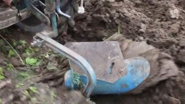 Mini bir traktörün sökülebilir saban cihazıyla toprağı sürmek, tarım makineleşmesi.