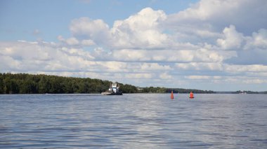 Güzel doğal nehir manzarası, mavi gökyüzü manzara bulutları ve yeşil orman ağaçları eski Rus teknesi ile birlikte yazın iki kırmızı şamandıranın yanında Volga Nehri 'nde yüzer.