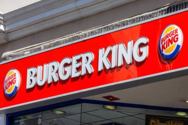 Londra, İngiltere, 1 Nisan 2012: Burger King sarı ve kırmızı logo reklam levhası şehir merkezindeki fast food perakende satış yapan bir restoranın önünde.