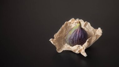 Siyah arka planda el işi paketlemedeki yalnız incirler.