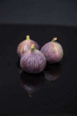  Olgunlaşmış incirler siyah camlarda yansıyor.