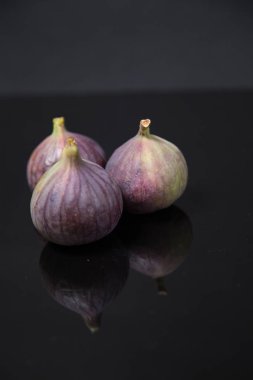  Olgunlaşmış incirler siyah camlarda yansıyor.