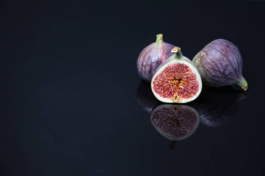  Olgunlaşmış incirler siyah camlarda yansıyor.