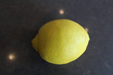 Gri bir yüzeyde koca bir limon