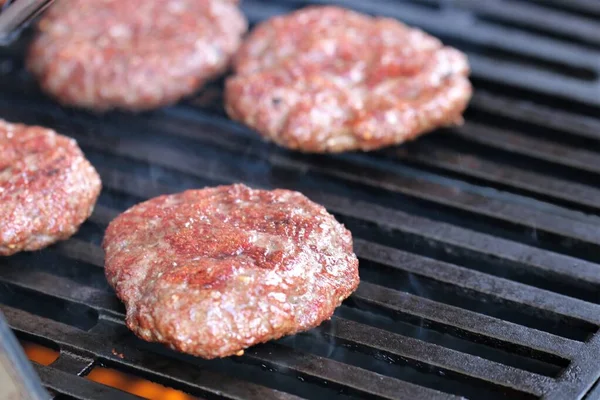 Several minced steaks on the gas grill — Stock Photo, Image
