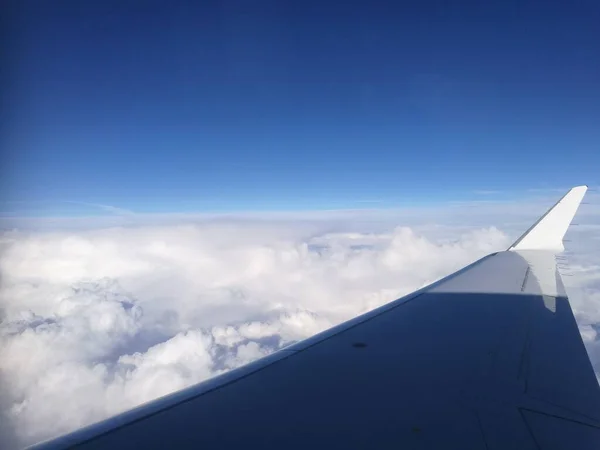 A asa de um avião com um fundo nublado — Fotografia de Stock