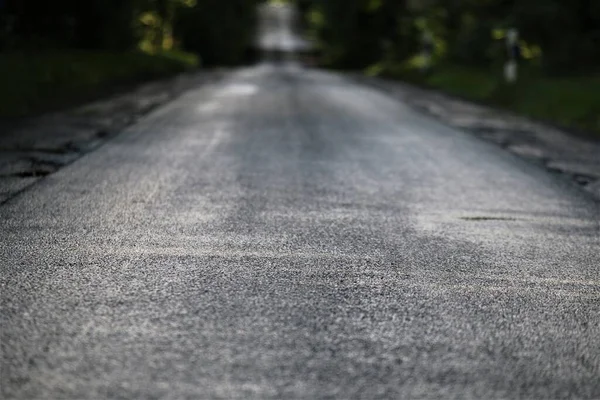 Strada asfaltata bagnata dopo la pioggia la sera — Foto Stock